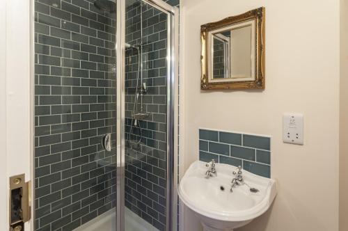 a bathroom with a sink and a shower at The Dog House, Porlock in Porlock