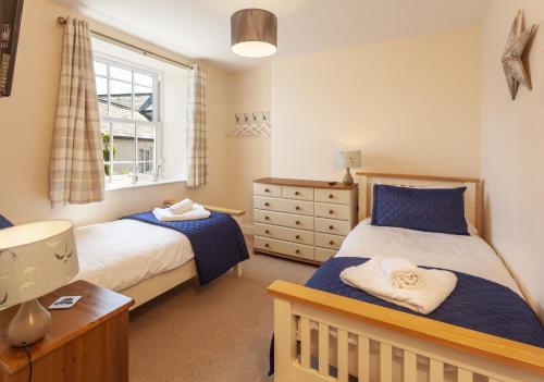 a bedroom with two beds and a window at The Dog House, Porlock in Porlock