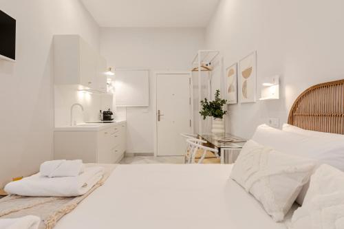 um quarto branco com uma cama grande e uma cozinha em Indulge Group: Downtown Cuna 1.0 em Sevilha