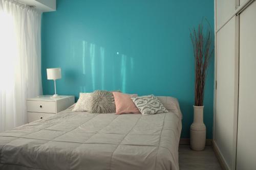 a bedroom with a large bed with a blue wall at Bernardita in Ramos Mejía