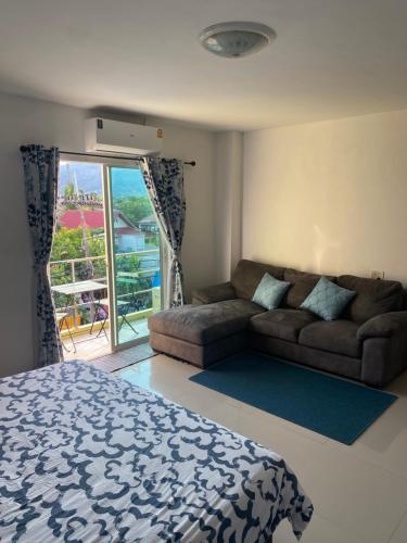 a living room with a bed and a couch at English owned Homestay and Yoga in Chalong 