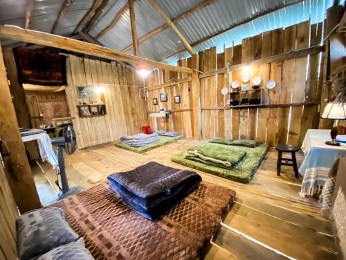 Zimmer mit 2 Betten in einem Holzzimmer in der Unterkunft Vườn Hoa Măng Đen Village in Kon Plong