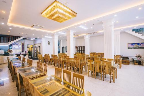 a restaurant with tables and chairs in a room at Hương Lý Hotel in Sầm Sơn