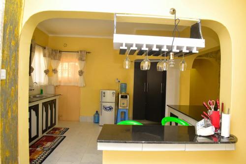 a kitchen with a black counter and yellow walls at Aggie's BnB in Nakuru