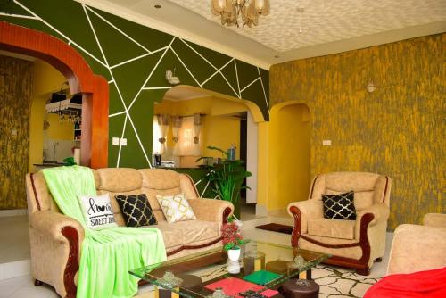 a living room with two chairs and a couch at Aggie's BnB in Nakuru