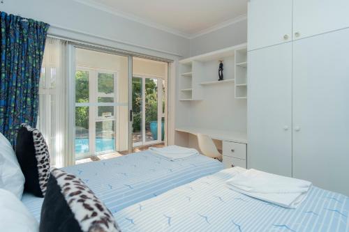 um quarto com uma cama e uma grande janela em Hout Bay Hilltop em Hout Bay