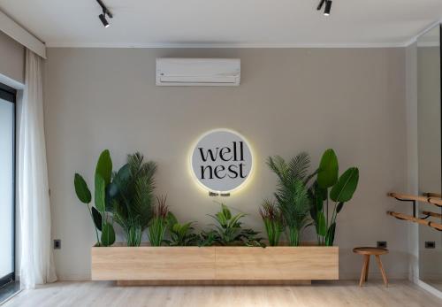 a wall with plants in a room with a well nest sign at Boutique Nest in New Cairo in Cairo