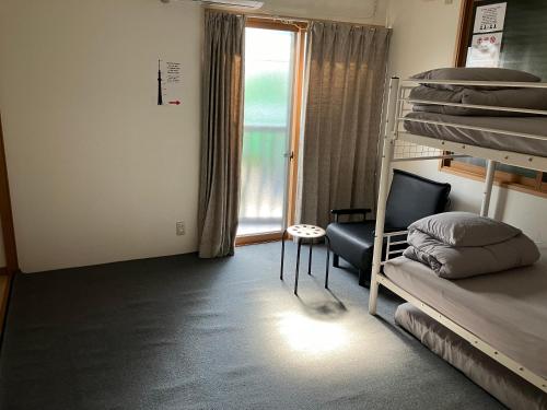 a room with bunk beds and a chair and a window at -0 meter to station- Tokyo, Asakusa, Ueno, Skytree tower and Akihabara entire house for 14 guests -駅まで0メートル- 東京 浅草 上野 スカイツリー 秋葉原一棟貸切14名様 in Tokyo