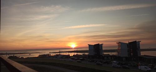 a sunset over a city with buildings and the ocean at Küstenkoje in Wendtorf