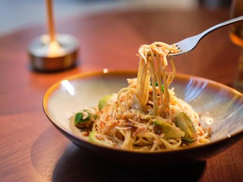 a bowl of noodles with a fork in it at voco Osaka Central by IHG in Osaka