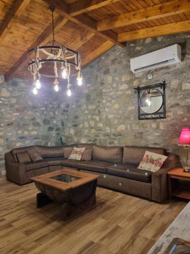 een woonkamer met een bank en een tafel bij House with big garden and barbeque in nature in Potamiá