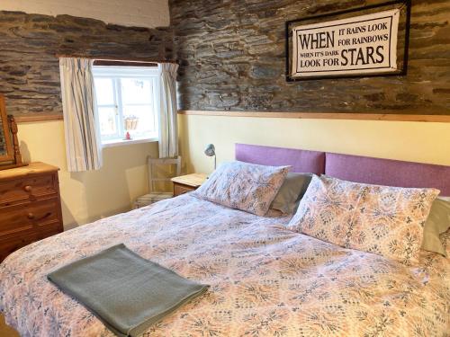 a bedroom with a bed and a sign on the wall at The Old Stables Brongest in Troedyraur