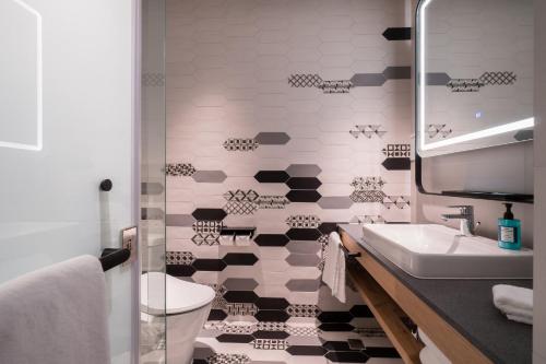 a bathroom with a black and white tiled wall at Holiday Inn Express Chiayi by IHG in Chiayi City