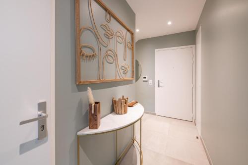 un couloir avec une table blanche et une porte dans l'établissement Élégance & Confort pr 6 à Disney - Fairytale Factory, à Saint-Germain-sur-Morin