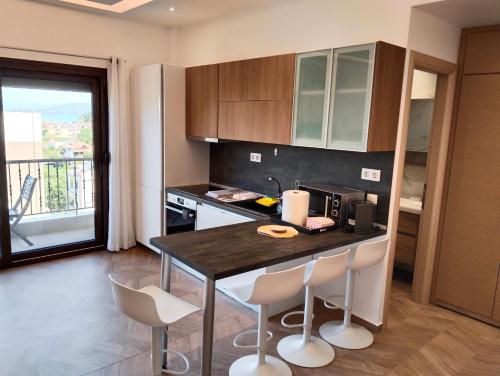 a kitchen with a table and chairs and a balcony at theasis1 in Neos Marmaras