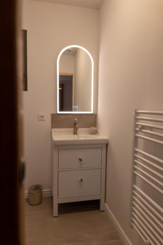une salle de bain avec un lavabo et un miroir dans l'établissement Comme à la maison, à Châteauneuf-de-Gadagne
