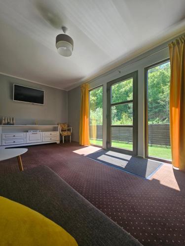 a large living room with windows and a tv at Relax and Smile Rameț in Biceşti