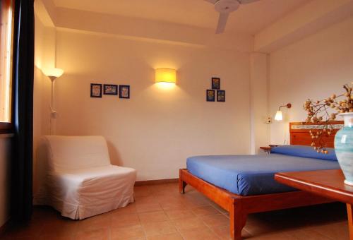 een slaapkamer met een bed, een stoel en een tafel bij VILLA PRATO in Sperlonga
