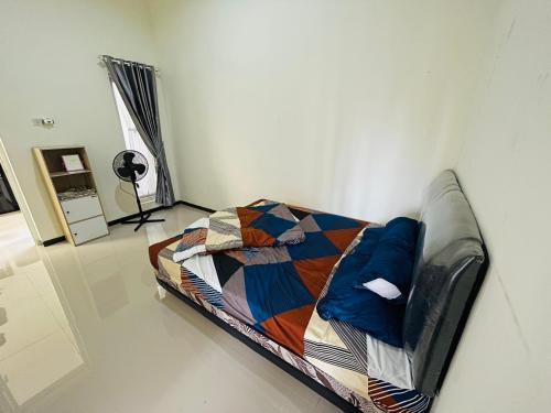 Bett in einem Zimmer mit einer Wand in der Unterkunft Villa Tanjung Alam Batu Syariah in Tlekung