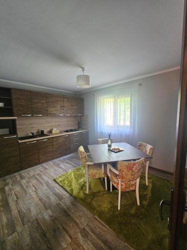 a kitchen with a table and chairs in a room at Relax and Smile Rameț in Biceşti