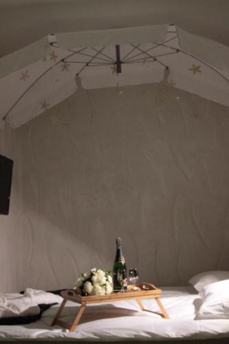 a table with a bottle and flowers on a bed at Kuredu / Uroa w Krainie Alicji in Ełk