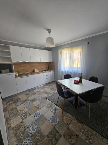 a kitchen with a table and chairs in a room at Relax and Smile Rameț in Biceşti