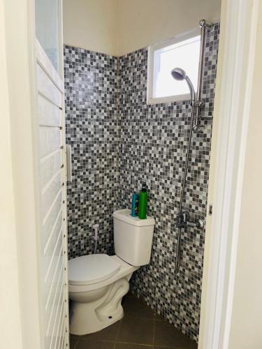 a bathroom with a toilet and a shower at Villa Tanjung Alam Batu Syariah in Tlekung