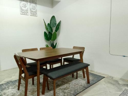 uma mesa de jantar com cadeiras e uma planta em MGH Homestay Bangi Wonderland em Kajang