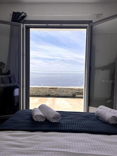 a bedroom with a bed with a view of the ocean at Endless Bleu Villa Andros Island in Apróvaton