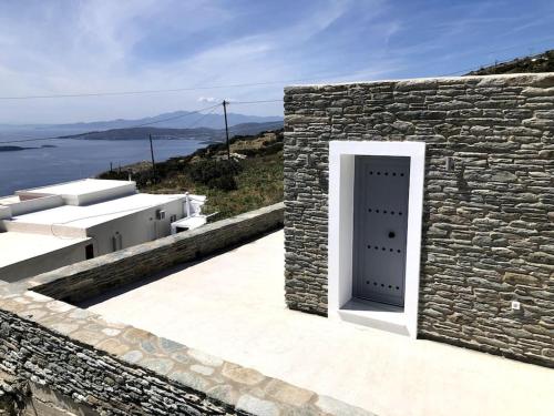 a stone building with a door on the side of it at Endless Bleu Villa Andros Island in Apróvaton