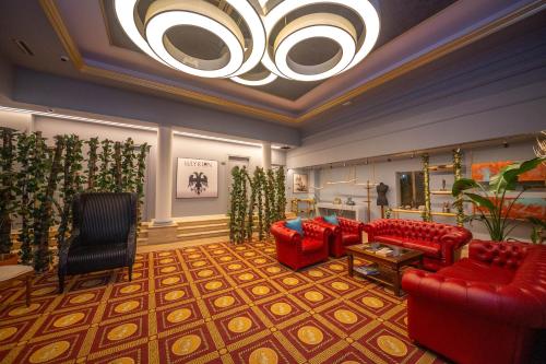 a living room with red furniture and a chandelier at Illyrian Boutique Hotel in Sarandë