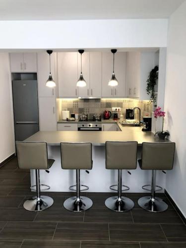 a kitchen with four chairs and a counter top at Endless Bleu Villa Andros Island in Apróvaton