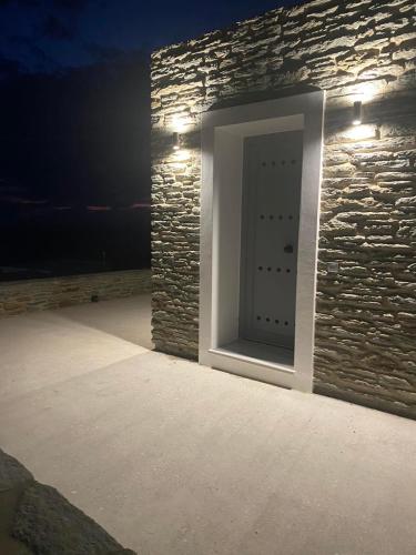 a door in a stone wall with lights on it at Endless Bleu Villa Andros Island in Apróvaton