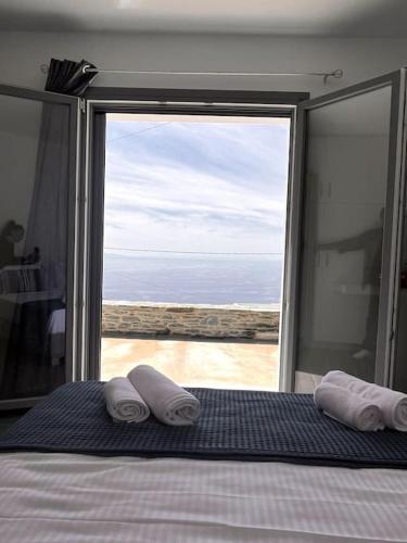 a bedroom with a bed with a view of the ocean at Endless Bleu Villa Andros Island in Apróvaton