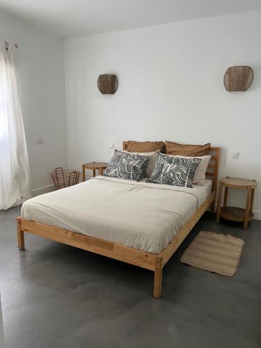 una cama de madera con almohadas en una habitación en Casa Cabrera - 2 apartamentos con vistas al mar en Caleta de Caballo