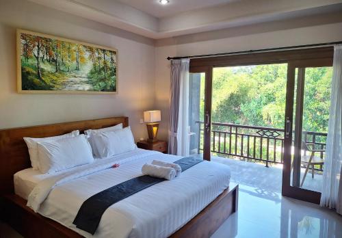 - une chambre avec un grand lit et un balcon dans l'établissement Bambu Lokha Guest house, Gianyar Bali, à Ubud