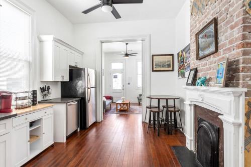 a kitchen with a brick fireplace and a table at Private 2BR Condo in Uptown by Hosteeva in New Orleans