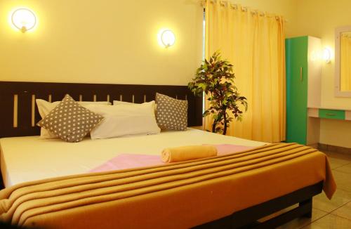 a bedroom with a large bed with an orange blanket at Marari Blue Waves in Mararikulam