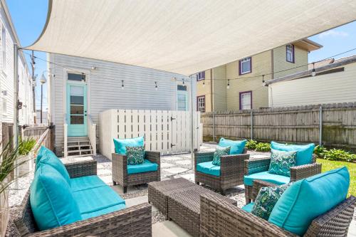 an outdoor patio with blue cushions and chairs at Private 2BR Condo in Uptown by Hosteeva in New Orleans