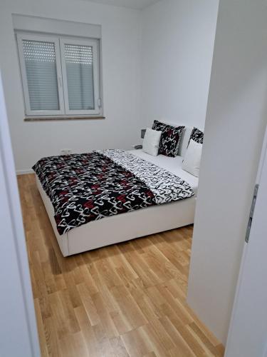 a bedroom with a bed in a room with a window at Apartman San in Posušje