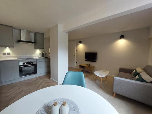 cocina y sala de estar con mesa y sofá en The Undercroft - central Leamington, en Leamington Spa