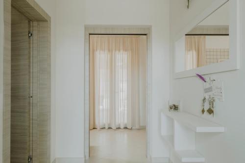 een witte badkamer met een wastafel en een douche bij Villa Patrizia Salento B&B in Porto Cesareo