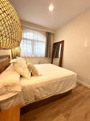 1 dormitorio con cama blanca y ventana grande en Main Beach - Lavalle Apartamentos, en Loredo