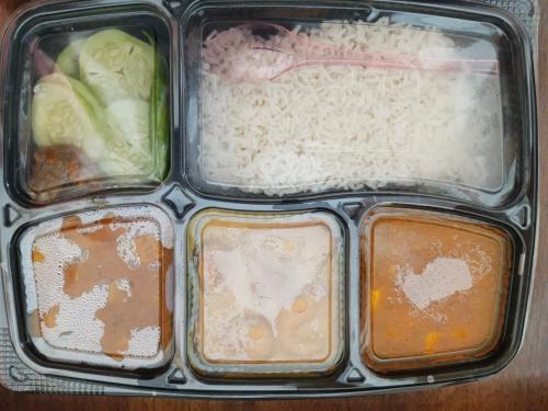a plastic container of food with rice and vegetables at Anaya Guest House Etah in Etah