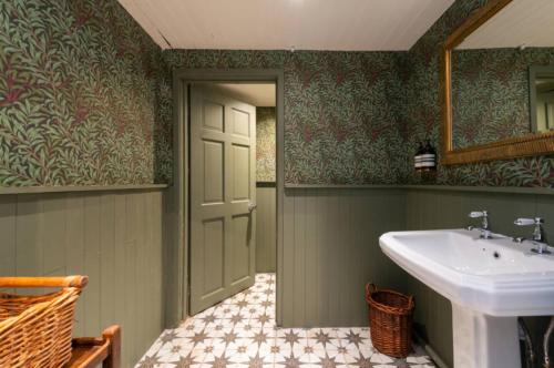 baño con lavabo blanco y puerta en Bowlish House, en Shepton Mallet