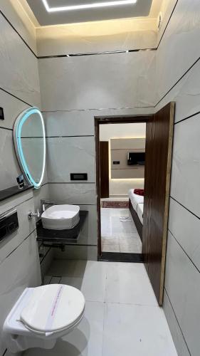 a bathroom with a toilet and a sink and a mirror at The Vacation Villa in Agra