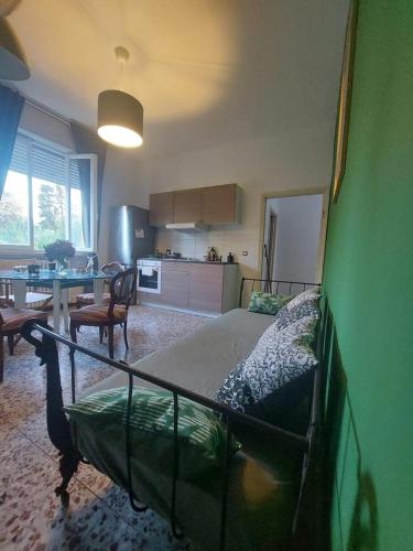 a bedroom with a bed and a table and a kitchen at Sauro 43 in Pisa