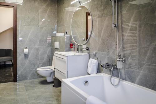 a bathroom with a tub and a toilet and a sink at Rezidencia Levočský Pivovar in Levoča