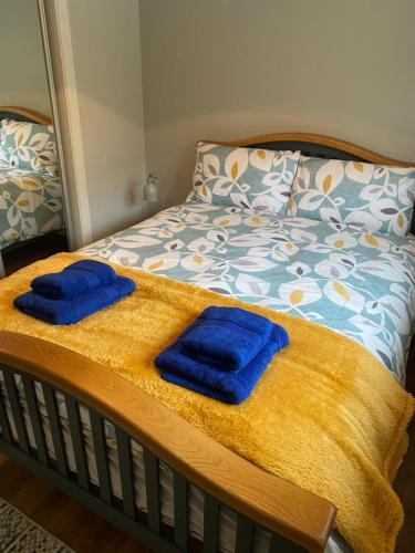 two blue towels are sitting on a bed at Grandma's Cottage in Greencastle