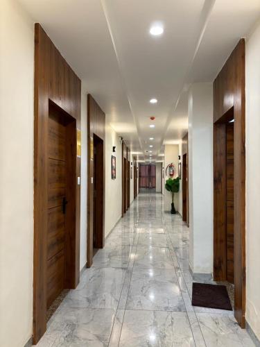 a hallway with wooden doors and a tile floor at Hotel Lee Pride in Anand